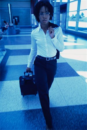simsearch:700-00071171,k - Businesswoman Walking in Terminal Pulling Luggage Fotografie stock - Rights-Managed, Codice: 700-00071164
