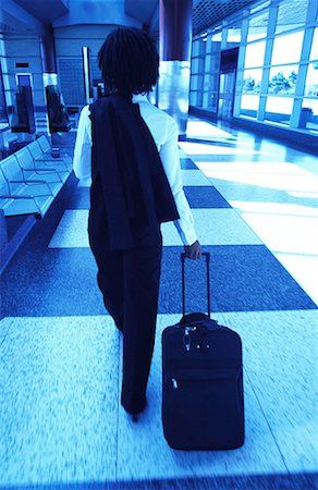 simsearch:700-00071171,k - Back View of Businesswoman Pulling Luggage in Terminal Fotografie stock - Rights-Managed, Codice: 700-00071165