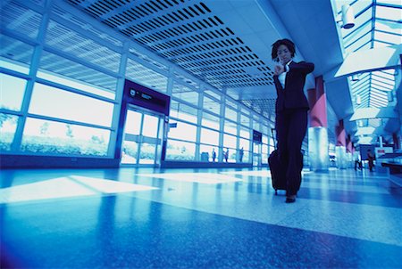 simsearch:700-00071171,k - Businesswoman Checking Watch Pulling Luggage in Terminal Stock Photo - Rights-Managed, Code: 700-00071168