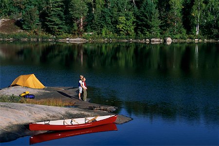 Couple Embracing near Lake with Tent and Canoe Haliburton, Ontario, Canada Stock Photo - Rights-Managed, Code: 700-00071226