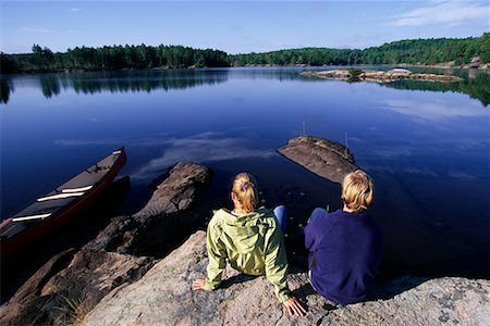Back View of Couple Sitting on Rock in Lake Haliburton, Ontario, Canada Stock Photo - Rights-Managed, Code: 700-00071230