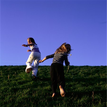 Back View of Two Girls Running Through Field Fotografie stock - Rights-Managed, Codice: 700-00071644