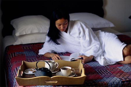 Femme allongée sur le lit lecture livre avec plateau de petit déjeuner Photographie de stock - Rights-Managed, Code: 700-00072018