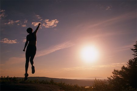 simsearch:700-00091198,k - Vue arrière du femme sur rocher sautant en l'Air au coucher du soleil Photographie de stock - Rights-Managed, Code: 700-00072229