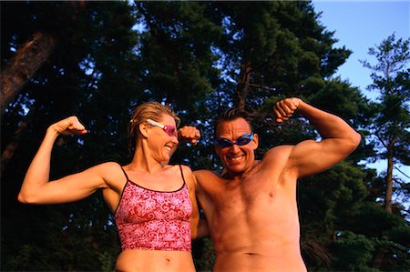 Portrait of Couple in Swimwear Flexing Muscles Outdoors Foto de stock - Con derechos protegidos, Código: 700-00072242