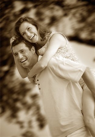 Couple Laughing, Man Giving Woman Piggyback Ride Outdoors Belgrade Lakes, Maine, USA Stock Photo - Rights-Managed, Code: 700-00072278