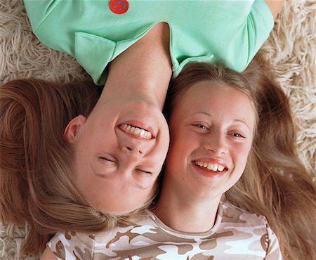 simsearch:700-00086687,k - Two Teenage Girls Lying Side by Side on Floor, Laughing Fotografie stock - Rights-Managed, Codice: 700-00073099