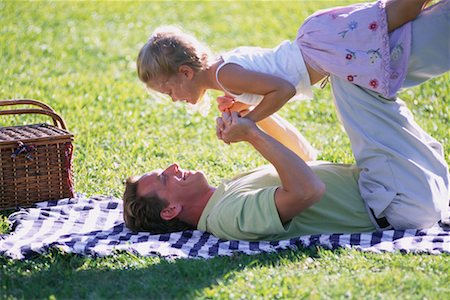 family picnics play - Father Lying on Blanket in Field Lifting Daughter in Air Stock Photo - Rights-Managed, Code: 700-00073557