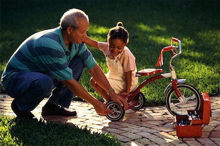 Grandfather and Granddaughter Fixing Tricycle Outdoors Stock Photo - Rights-Managed, Code: 700-00073610