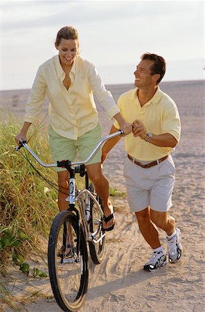 Man Helping Woman Ride Bike on Beach Stock Photo - Rights-Managed, Code: 700-00073946