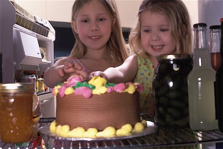 Two Girls Tasting Birthday Cake In Fridge Stock Photo - Rights-Managed, Code: 700-00084099
