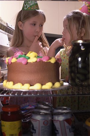 Two Girls Tasting Birthday Cake In Fridge Stock Photo - Rights-Managed, Code: 700-00084100