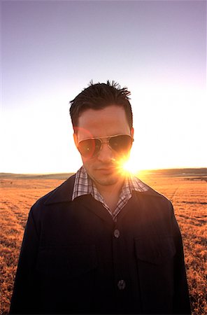 Porträt des Mannes mit Sonnenbrille, stehend im Feld bei Sonnenuntergang Stockbilder - Lizenzpflichtiges, Bildnummer: 700-00084906