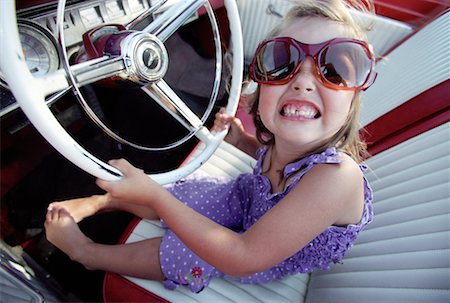 Portrait of Girl Wearing Sunglasses at Steering Wheel of Car Stock Photo - Rights-Managed, Code: 700-00084909