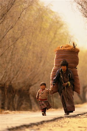Mother and Child Walking on Road Carrying Bag on Back Paro Valley, Bhutan Stock Photo - Rights-Managed, Code: 700-00085127