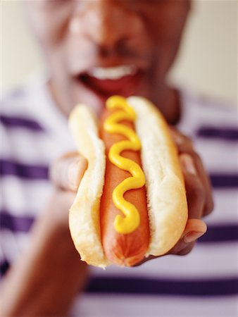 ethnic man eating hot dog - Close-Up of Man Eating Hot Dog Stock Photo - Rights-Managed, Code: 700-00086061