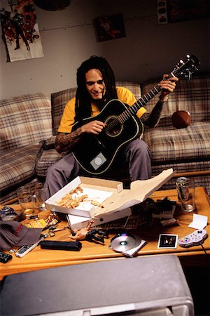 simsearch:700-00077881,k - Man Sitting on Sofa, Playing Guitar with Pizza Box on Table Stock Photo - Rights-Managed, Code: 700-00086134