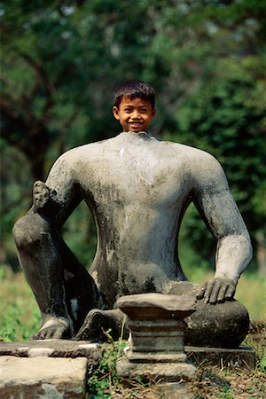 Portrait of Boy Behind Statue Phimeanakas Temple Complex Siem Reap, Cambodia Stock Photo - Rights-Managed, Code: 700-00086665