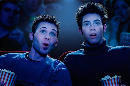 Two Young Men Watching Movie in Theatre Stock Photo - Rights-Managed, Code: 700-00086715