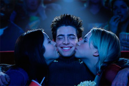 Two Young Women Kissing Young Man On Cheeks in Movie Theatre Stock Photo - Rights-Managed, Code: 700-00086718