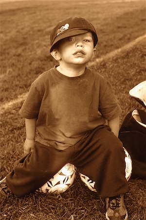 Portrait of Boy Sitting on Soccer Ball Outdoors Stock Photo - Rights-Managed, Code: 700-00087012