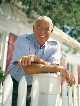 Portrait d'homme d'âge mûr se penchant sur la clôture, souriant à l'extérieur Photographie de stock - Rights-Managed, Code: 700-00087070
