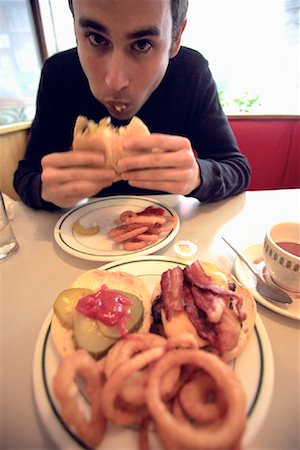 picture of man sitting alone diner - Man Eating Hamburger Stock Photo - Rights-Managed, Code: 700-00088232