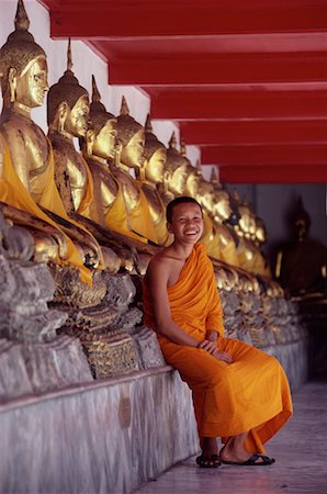 Portrait of Monk Sitting by Buddha Statues at Wat Po Bangkok, Thailand Stock Photo - Rights-Managed, Code: 700-00080037
