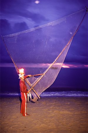Portrait of Man with Fishing Net And Kerosene Head Lamp on Beach Pantai Kundor, Malaysia Fotografie stock - Rights-Managed, Codice: 700-00080152