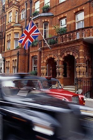 Blurred View of Taxis on Street Near Building with British Flag London, England Stock Photo - Rights-Managed, Code: 700-00081255