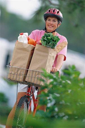 riding bike with basket - Mature Woman Riding Bike with Bags of Groceries Stock Photo - Rights-Managed, Code: 700-00081396