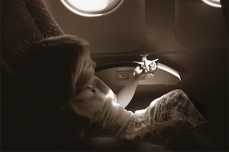 Girl Sitting in Airplane, Playing With Toy Airplane Stock Photo - Rights-Managed, Code: 700-00081669