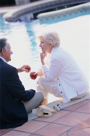 party couple pool - Mature Couple Sitting by Pool, Holding Glasses of Wine Stock Photo - Rights-Managed, Code: 700-00081887