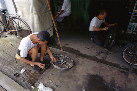 picture of old man on a bike - Men Working in Bike Repair Shop Singapore Stock Photo - Rights-Managed, Code: 700-00082161