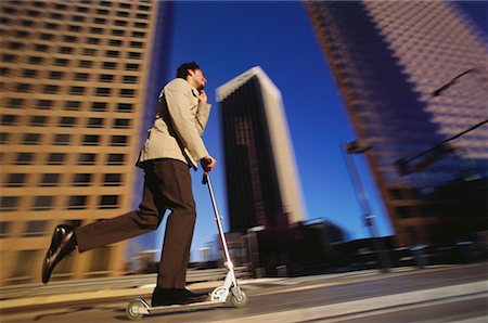 Businessman Using Scooter and Cell Phone by Office Towers Los Angeles, California, USA Stock Photo - Rights-Managed, Code: 700-00082218