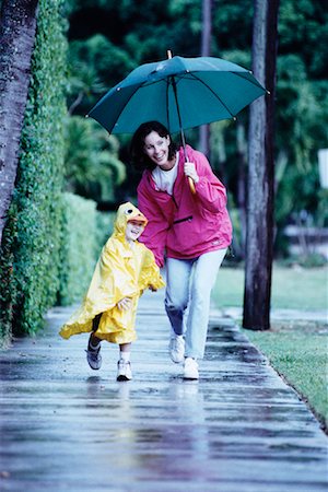 rain coat for boys - Mother and Child Walking on Sidewalk in Rain Stock Photo - Rights-Managed, Code: 700-00083592