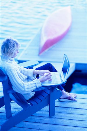 Woman Sitting on Dock Using Laptop Stock Photo - Rights-Managed, Code: 700-00096128