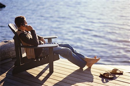 Person Sitting on Dock Using Cell Phone Stock Photo - Rights-Managed, Code: 700-00096136