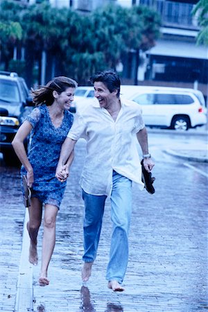 couple holding hands in rain