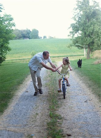 dad teaching child to ride bike - Child Learning to Ride Bicycle Stock Photo - Rights-Managed, Code: 700-00092693