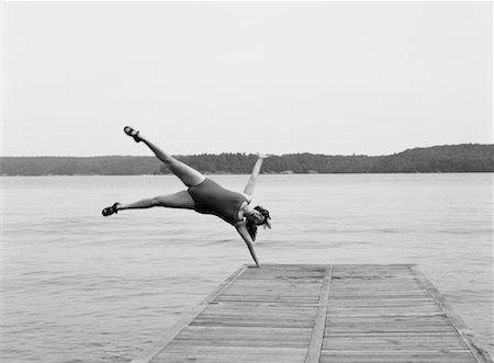 Woman Doing Cartwheel off Dock Foto de stock - Con derechos protegidos, Código: 700-00092715