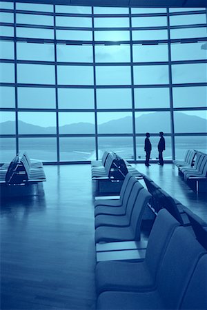 pictures of two people talking at the airport - Two Businessmen by Window in Airport Waiting Area Stock Photo - Rights-Managed, Code: 700-00155934