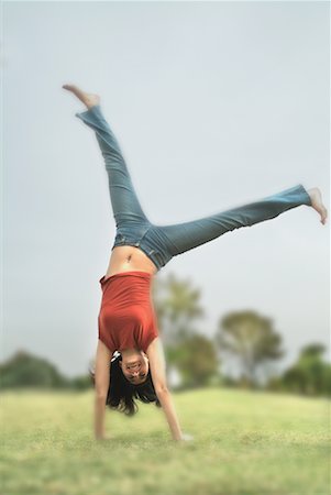 person mid air flip - Young Woman Doing Cartwheel Stock Photo - Rights-Managed, Code: 700-00157308