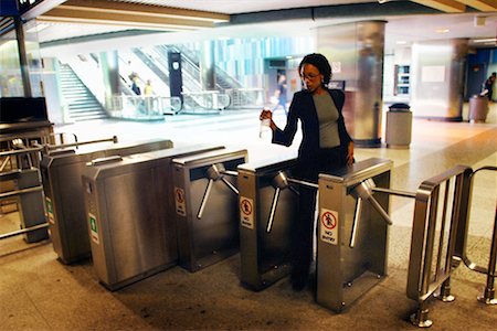 Woman Going Through Turnstile Fotografie stock - Rights-Managed, Codice: 700-00158999