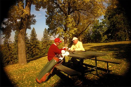 Mature Men Sitting at Picnic Table on Golf Course Stock Photo - Rights-Managed, Code: 700-00150680