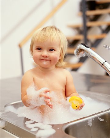 Baby Bathing In Kitchen Sink Foto de stock - Con derechos protegidos, Código: 700-00152187