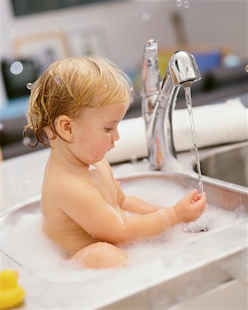 Baby Bathing In Kitchen Sink Foto de stock - Con derechos protegidos, Código: 700-00152188