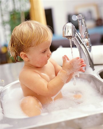 Baby Bathing In Kitchen Sink Foto de stock - Con derechos protegidos, Código: 700-00152189