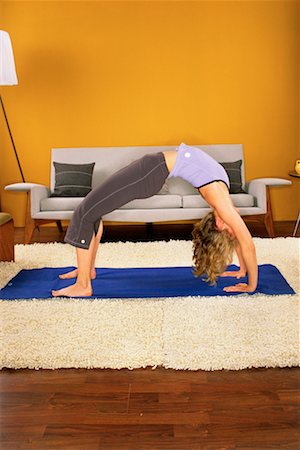 posición de rueda - Woman Practising Yoga in Her Living Room Foto de stock - Con derechos protegidos, Código: 700-00152544