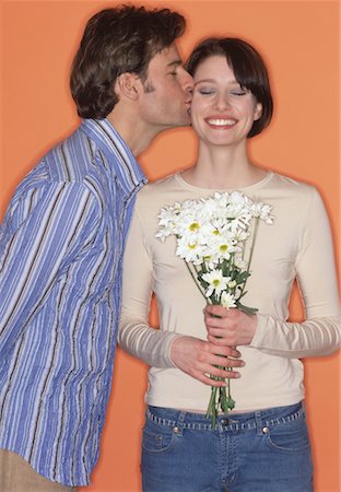 simsearch:700-00038851,k - Homme embrasser femme tenant des fleurs Photographie de stock - Rights-Managed, Code: 700-00165214